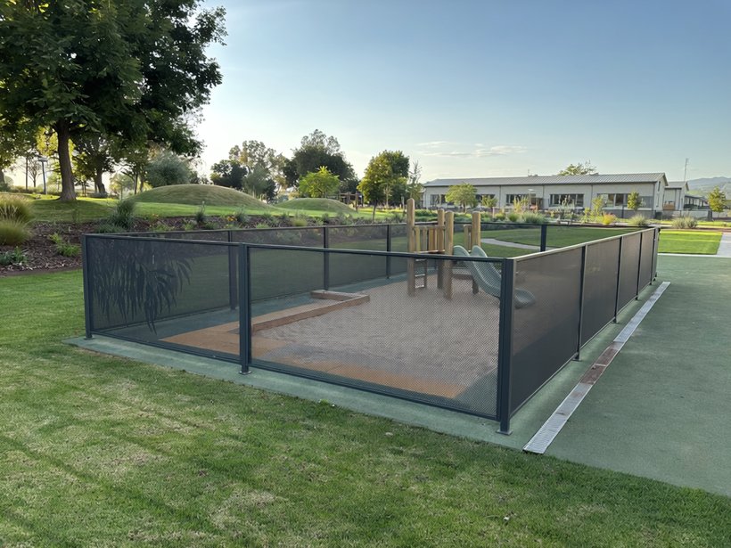 Childcare outdoor play area with shade sails and a see-through Perf Safe fence